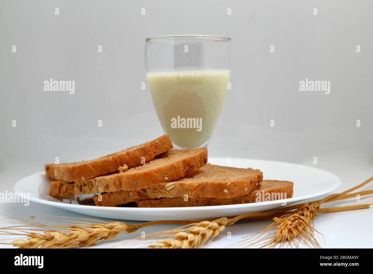 Frisches Brot mit Milchglas in einem Keramikplatte. Stockfoto