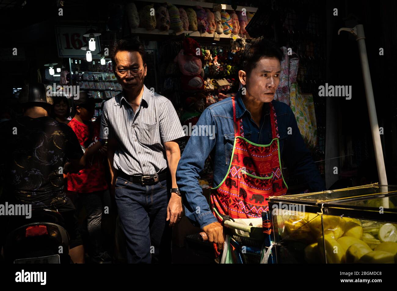 Frau am Telefon vor einem Geschäft, Chinatown, Bangkok, Thailand Stockfoto