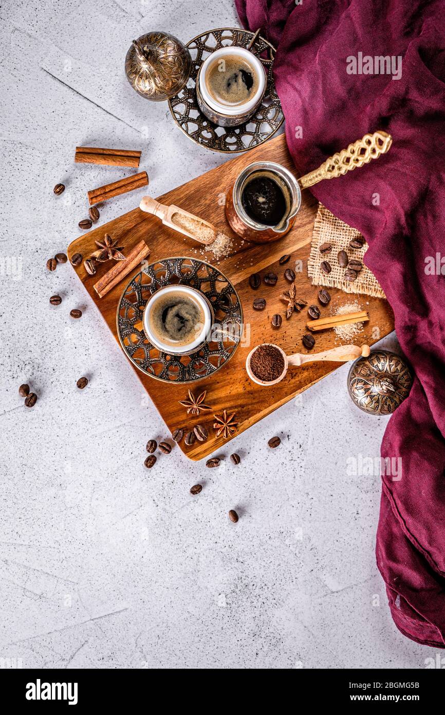 Weißer Couchtisch mit Kaffeebohnen, gemahlenem Pulver und Gewürzen. Arabischer Kaffee im traditionellen Stil Stockfoto