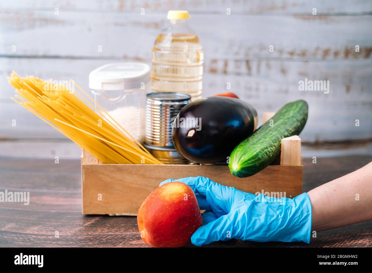 Lebensmittel. Krise Lebensmittel Box Lager für Coronavirus Quarantäne Isolationszeit in Holz Hintergrund. Verschiedene Lebensmittel in Aluminiumdosen, Reis, Nudeln, Öl Stockfoto