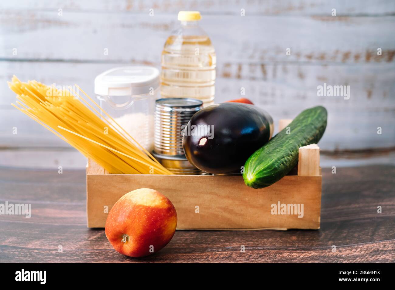 Lebensmittel. Krise Lebensmittel Box Lager für Coronavirus Quarantäne Isolationszeit in Holz Hintergrund. Verschiedene Lebensmittel in Aluminiumdosen, Reis, Nudeln, Öl Stockfoto
