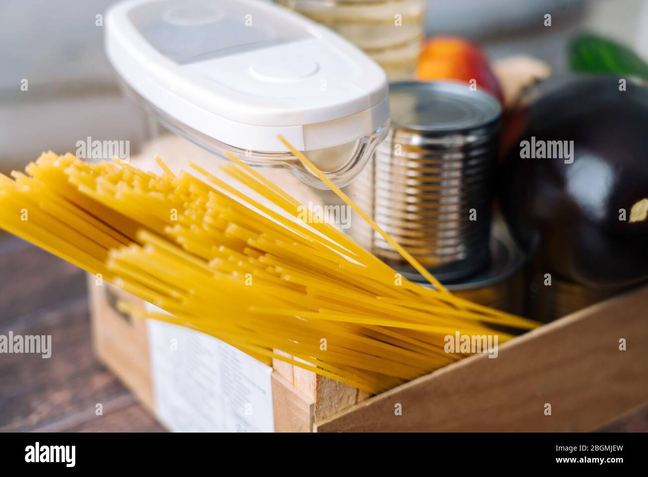 Lebensmittel. Krise Lebensmittel Box Lager für Coronavirus Quarantäne Isolationszeit in Holz Hintergrund. Verschiedene Lebensmittel in Aluminiumdosen, Reis, Nudeln, Öl Stockfoto