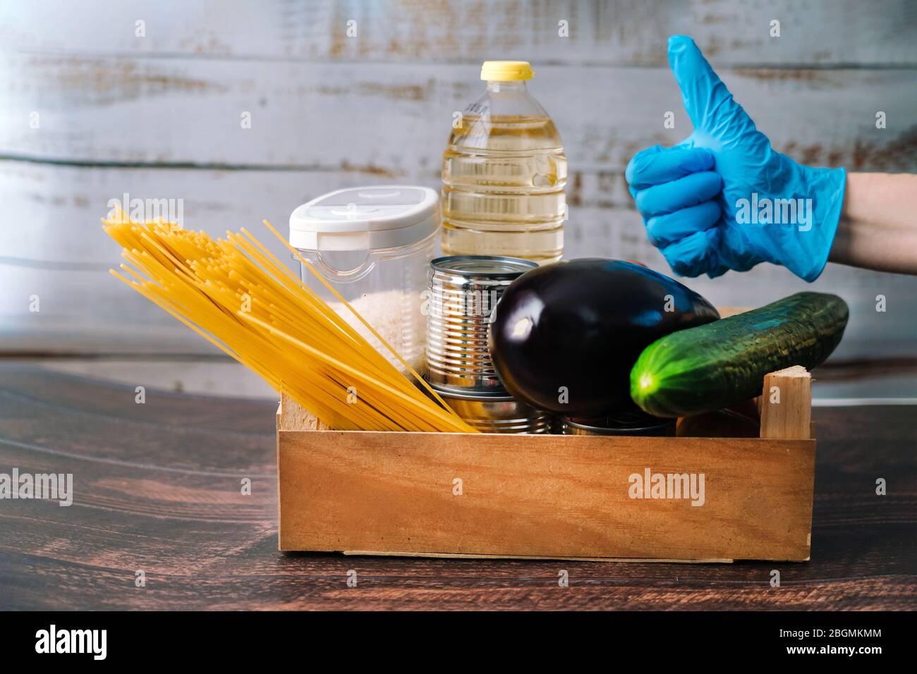 Lebensmittel. Krise Lebensmittel Box Lager für Coronavirus Quarantäne Isolationszeit in Holz Hintergrund. Verschiedene Lebensmittel in Aluminiumdosen, Reis, Nudeln, Öl Stockfoto