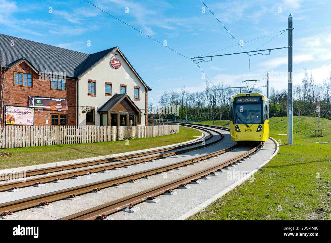 Metrolink Tram vorbei am Coppice Wood Farm Restaurant am Eröffnungstag der Trafford Park Line, Barton Dock Rd., Trafford Park, Manchester, Großbritannien Stockfoto