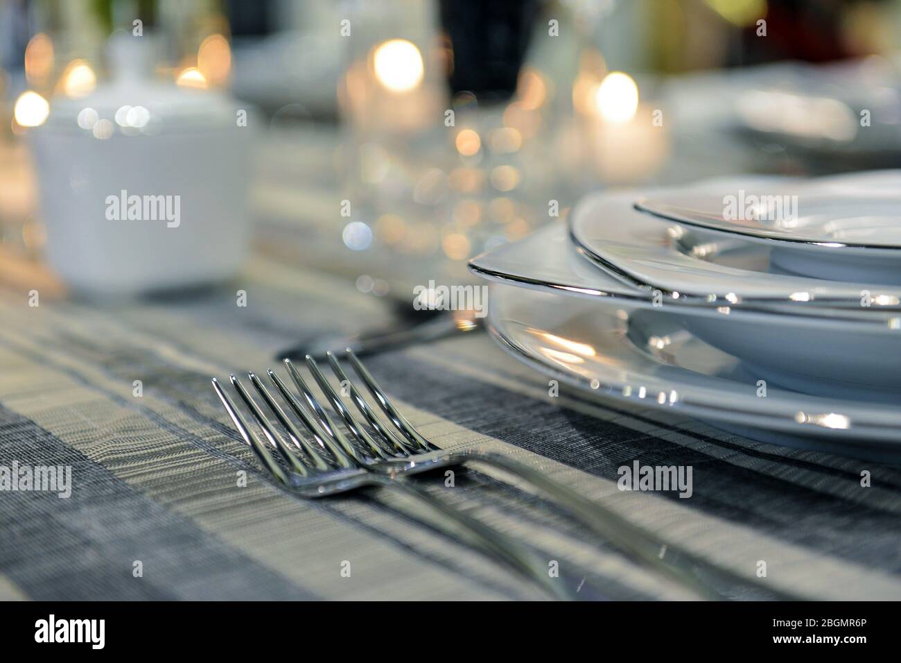 Tischeinstellung mit leerer Gästekarte auf leerem weißen Teller und Besteck auf Tisch, Kopierraum. Stockfoto