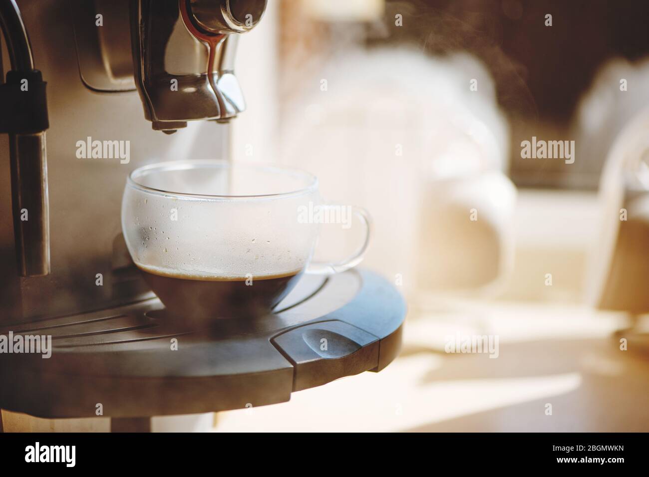 Kaffeemaschine, die heißen Espresso in eine Tasse gießt. Stockfoto