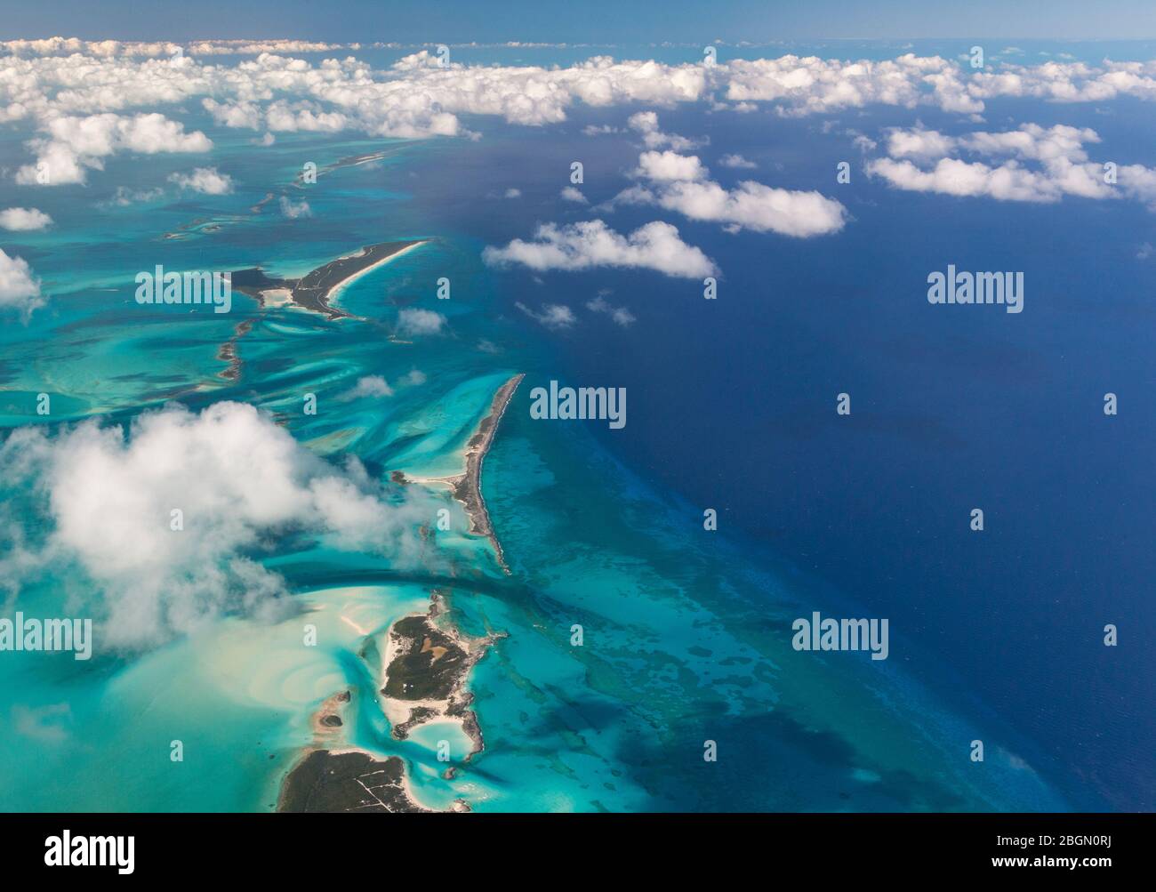 Luftaufnahme der Bahama Inseln und des umliegenden blauen Wassers, mit kleinen flauschigen weißen Wolken auf den Bahamas Stockfoto