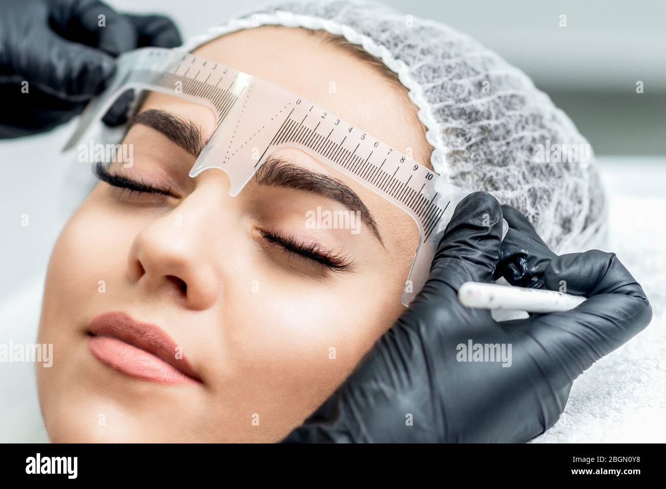 Markup mit Lineal auf Augenbrauen während der dauerhaften Make-up. Stockfoto