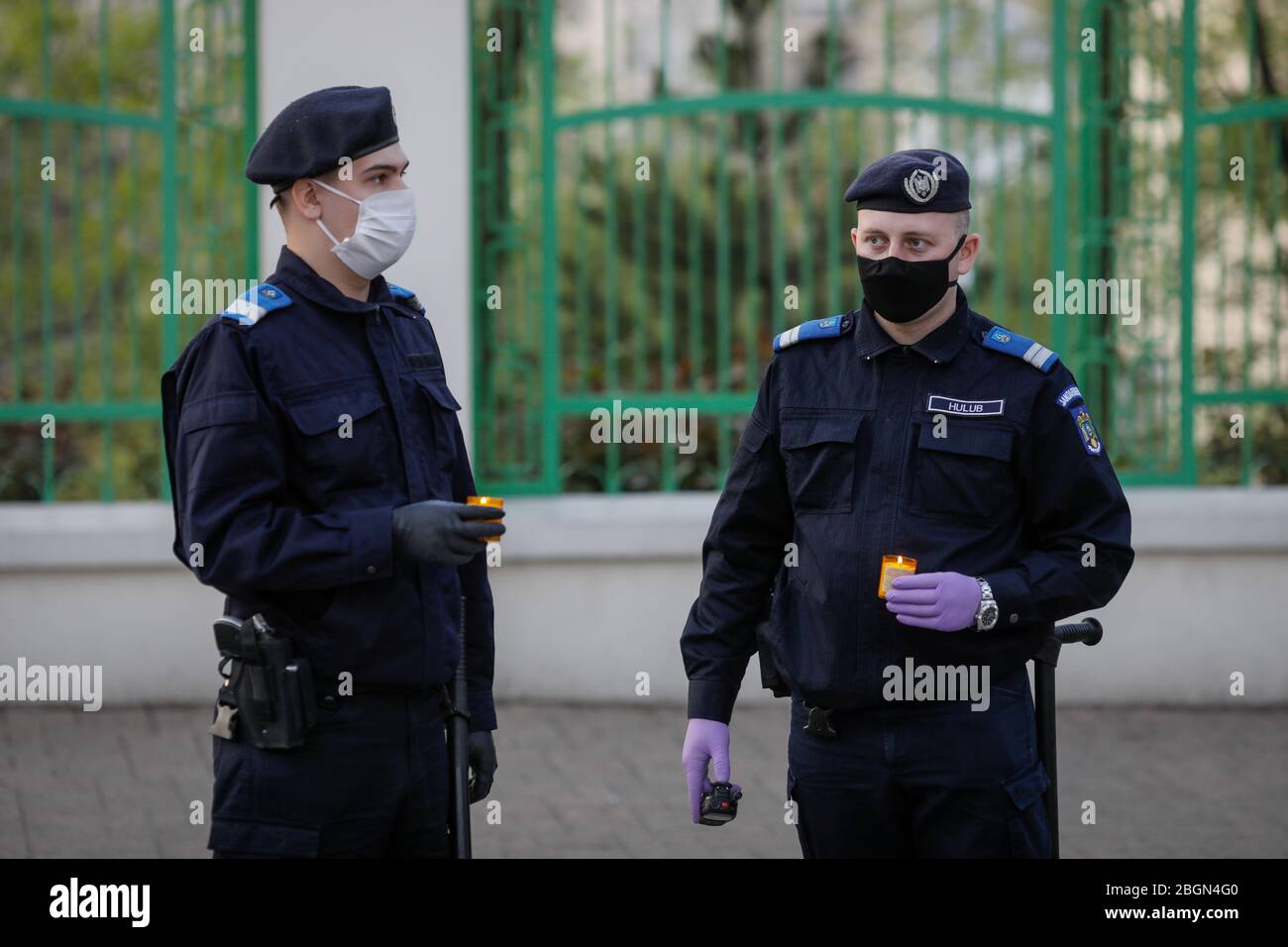 Bukarest, Rumänien - 18. April 2020: Rumänische Gendarmen mit chirurgischen Masken aufgrund der COVID-19 Pandemie nehmen das Heilige Licht während der orthodoxen Easte Stockfoto