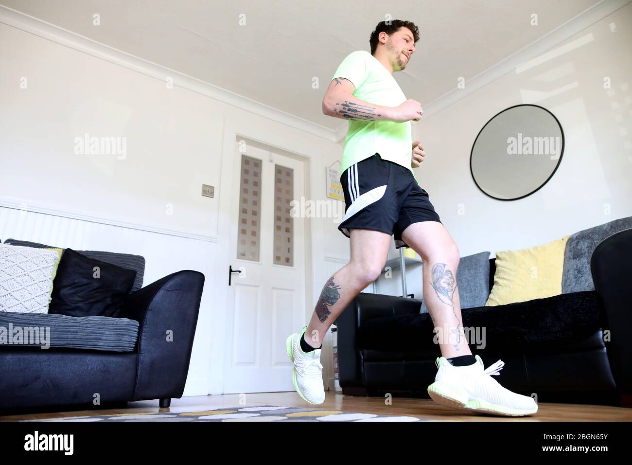 Col Bignell von Comber, Co Down trainiert in seinem Wohnzimmer, während er sich auf einen Marathon in seinem vorderen Raum vorbereitet, den er über 11,000 Mal hin und her laufen wird. Stockfoto