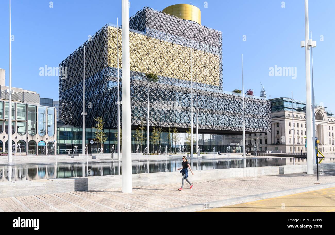 Birmingham, England, Großbritannien. April 2020. Am frühen Morgen 'Rush Hour' im Stadtzentrum von Birmingham während Woche 4 der nationalen Sperre als Reaktion auf die Coronavirus-Pandemie Covid-19. Ein einsamer Jogger geht an der Library of Birmingham am Centenary Square, Birmingham, Großbritannien vorbei. Bild: Simon Hadley/Alamy Stockfoto