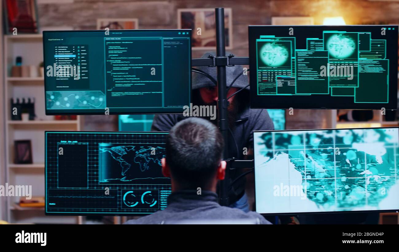 Organisiertes Team von Cyber-Kriminellen, die über ihr Sicherheitssystem sprechen. Gefährliche Hacker. Stockfoto