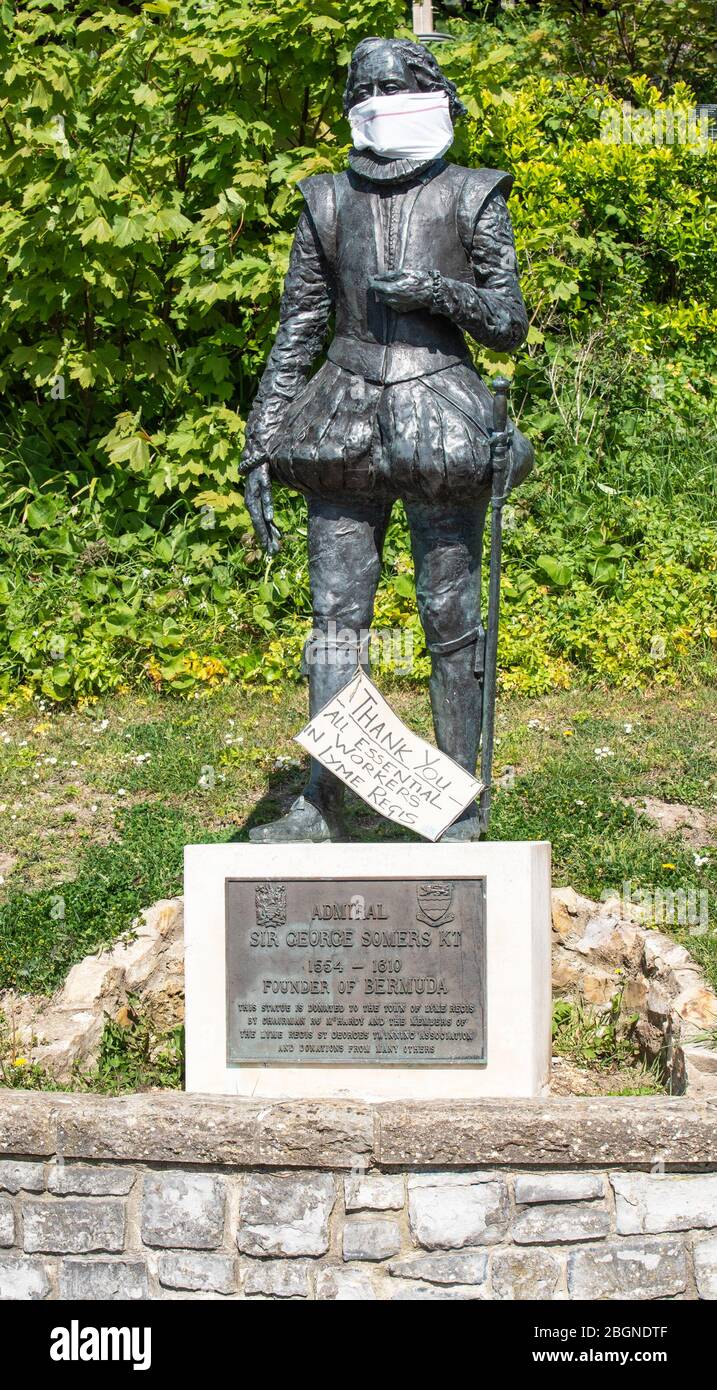 Lyme Regis, Dorset, Großbritannien. April 2020. UK Wetter: Heißer und sonniger Nachmittag bei Lyme Regis. Eine Statue von Admiral Sir George Somers KT (Gründer von Bemuda) in den Langmore Gardens, Lyme Regis donnerte eine Facemask als Geste der Wertschätzung und Dank an NHS-Mitarbeiter und Schlüsselarbeiter an der Frontlinie des Coronavirus. Kredit: Celia McMahon/Alamy Live News Stockfoto