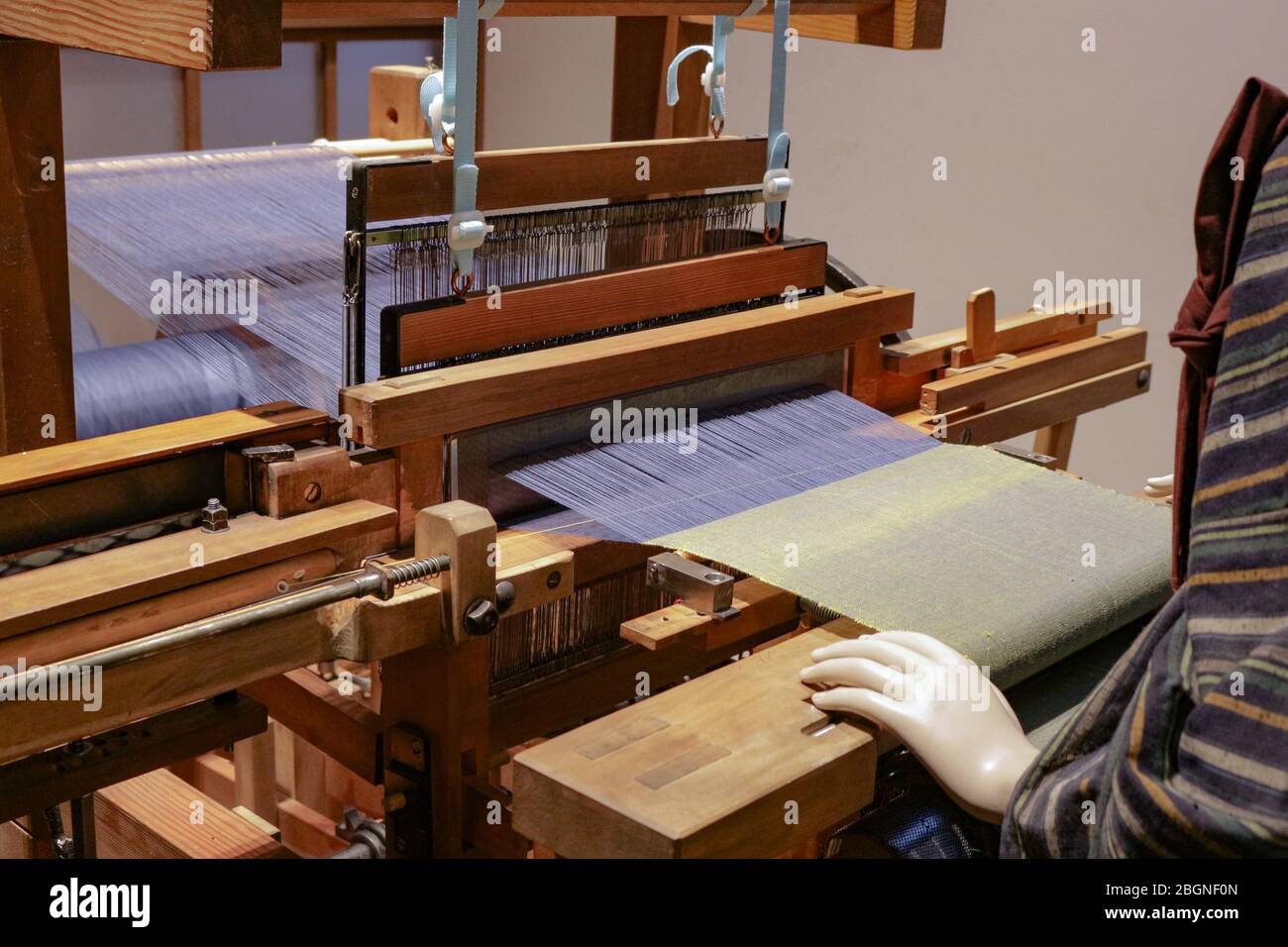Dies ist eine Webmaschine alte Schule, die Baumwollfaden webt, um ein nahtloses Kleidungsstück wie Teppiche Hemden etc. Zu machen Stockfoto