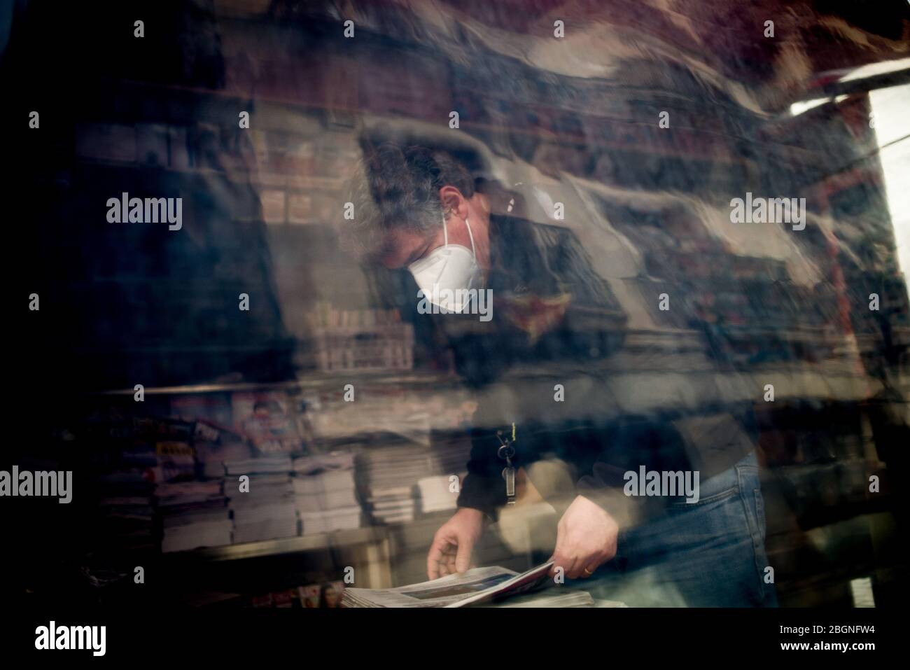 22. April 2020, Barcelona, Katalonien, Spanien - EIN Mann mit einer schützenden Gesichtsmaske stellt die Zeitungen in einem Kiosk in Barcelona zum Verkauf. Spanien wird mit der Deeskalation der Coronavirus-Maßnahmen beginnen, ohne das Auftreten der Epidemie zu kennen, stabilisieren sich die Sterbefälle des Coronavirus in den letzten 24 Stunden mit 435. Quelle: Jordi Boixareu/Alamy Live News Stockfoto