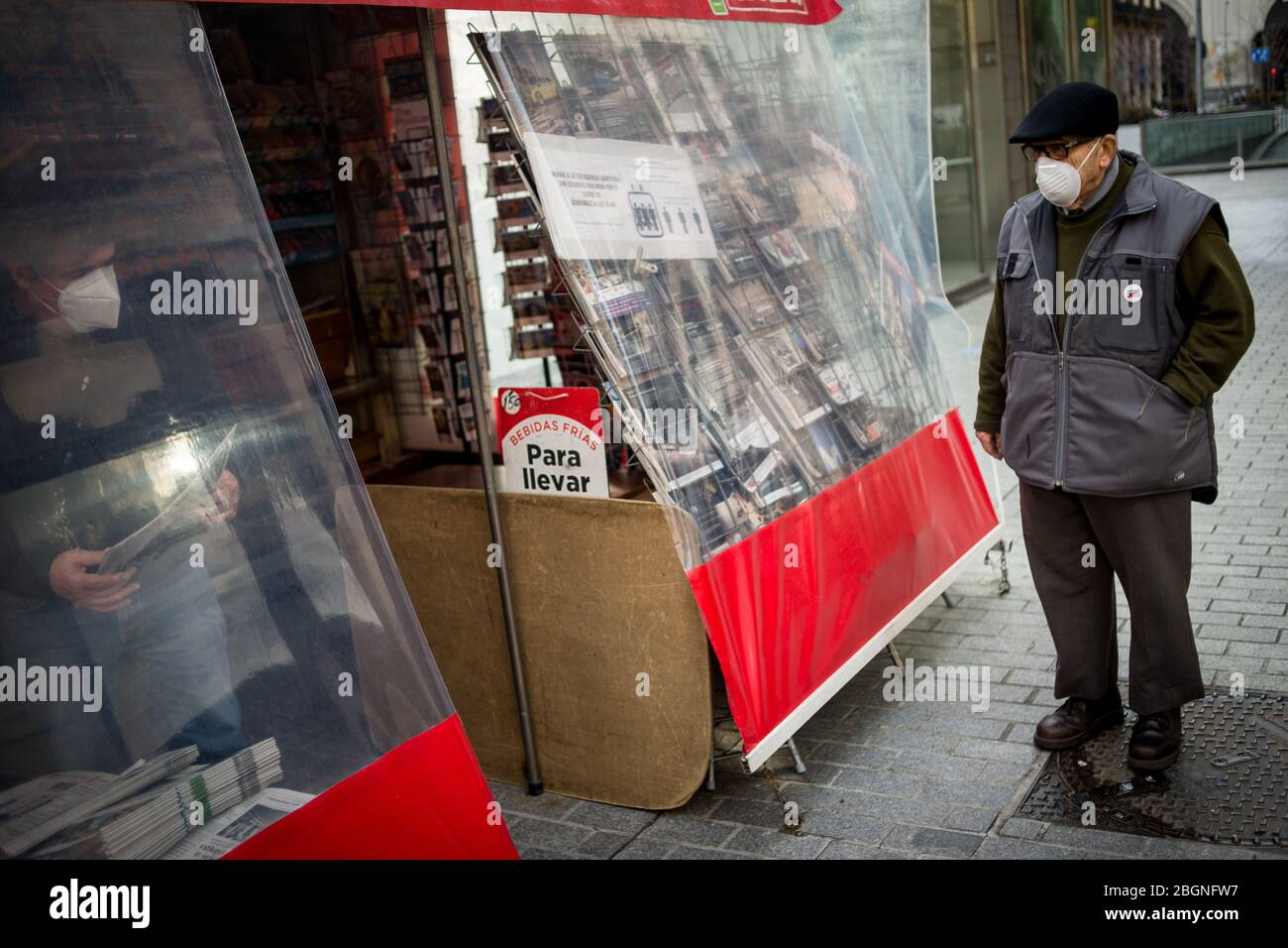 22. April 2020, Barcelona, Katalonien, Spanien - EIN Mann mit einer schützenden Gesichtsmaske wartet darauf, in einem Kiosk in Barcelona eine Zeitung zu kaufen. Spanien wird mit der Deeskalation der Coronavirus-Maßnahmen beginnen, ohne das Auftreten der Epidemie zu kennen, stabilisieren sich die Sterbefälle des Coronavirus in den letzten 24 Stunden mit 435. Quelle: Jordi Boixareu/Alamy Live News Stockfoto