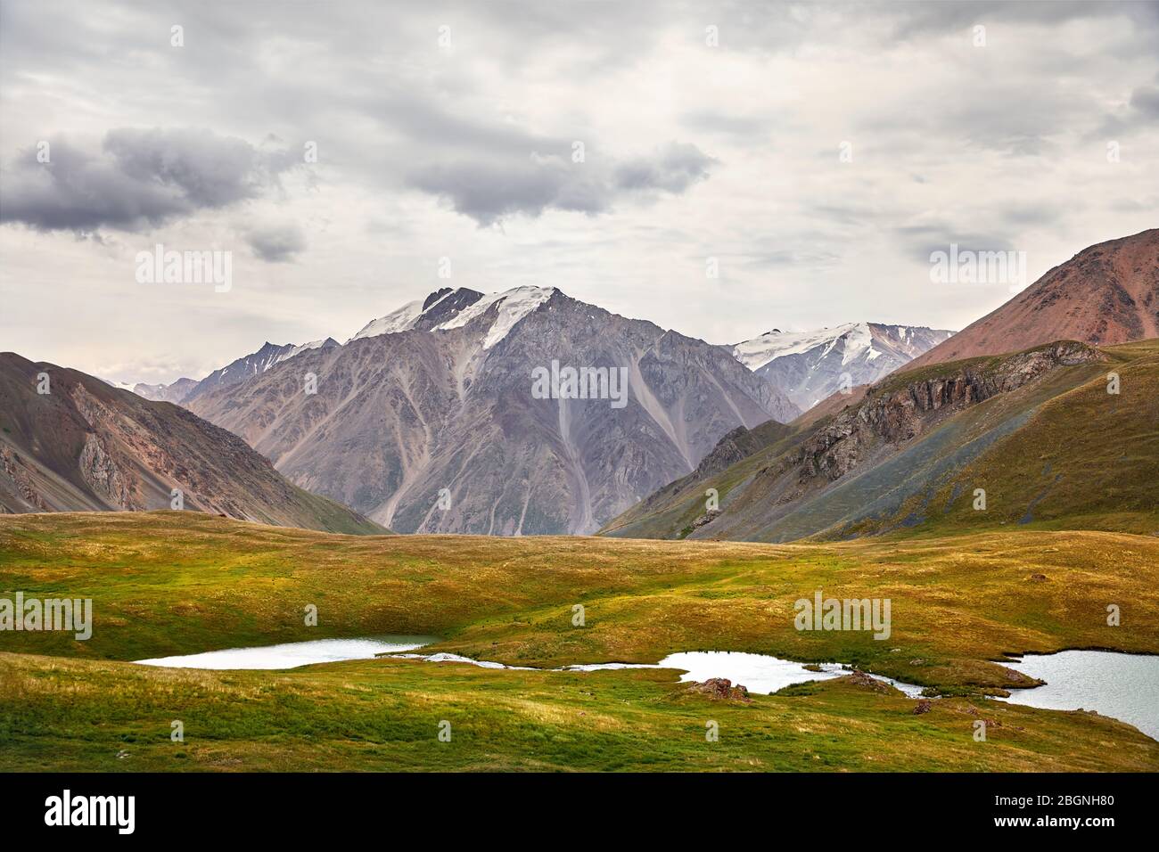 Schönen See und die hohen Berge im Tal gegen bewölkten Himmel in Kirgisistan Stockfoto