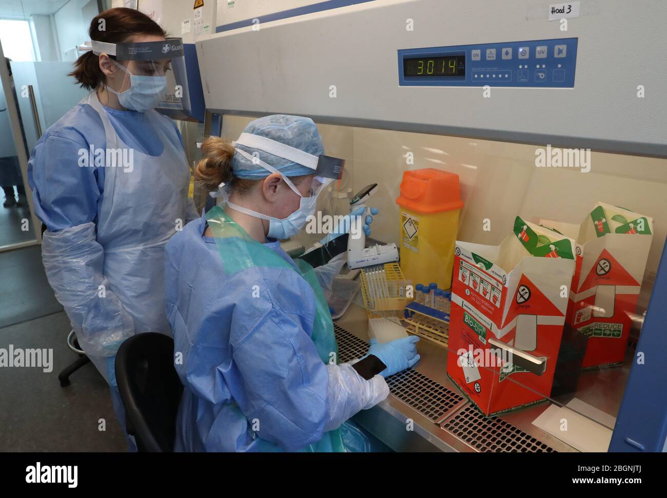 Techniker führen während der Eröffnung des neuen Covid-19-Testlabors am Queen Elizabeth University Hospital in Glasgow einen Probentransfer durch. Stockfoto