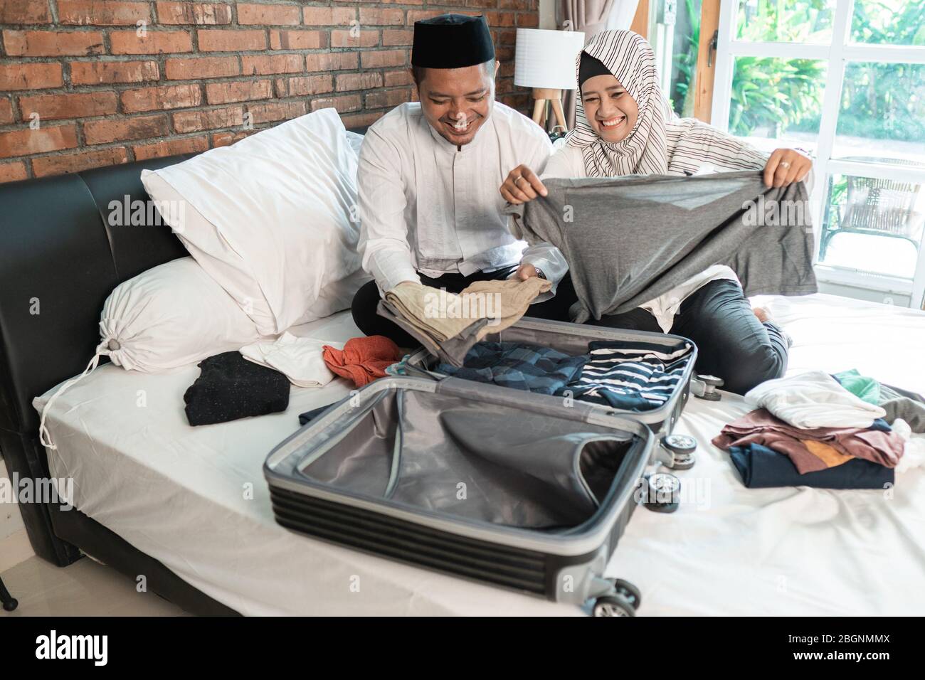 Glücklich muslimischen Paar Verpackung für den Urlaub Stockfoto Glücklich muslimischen Paar Verpackung für den Urlaub Stockfoto