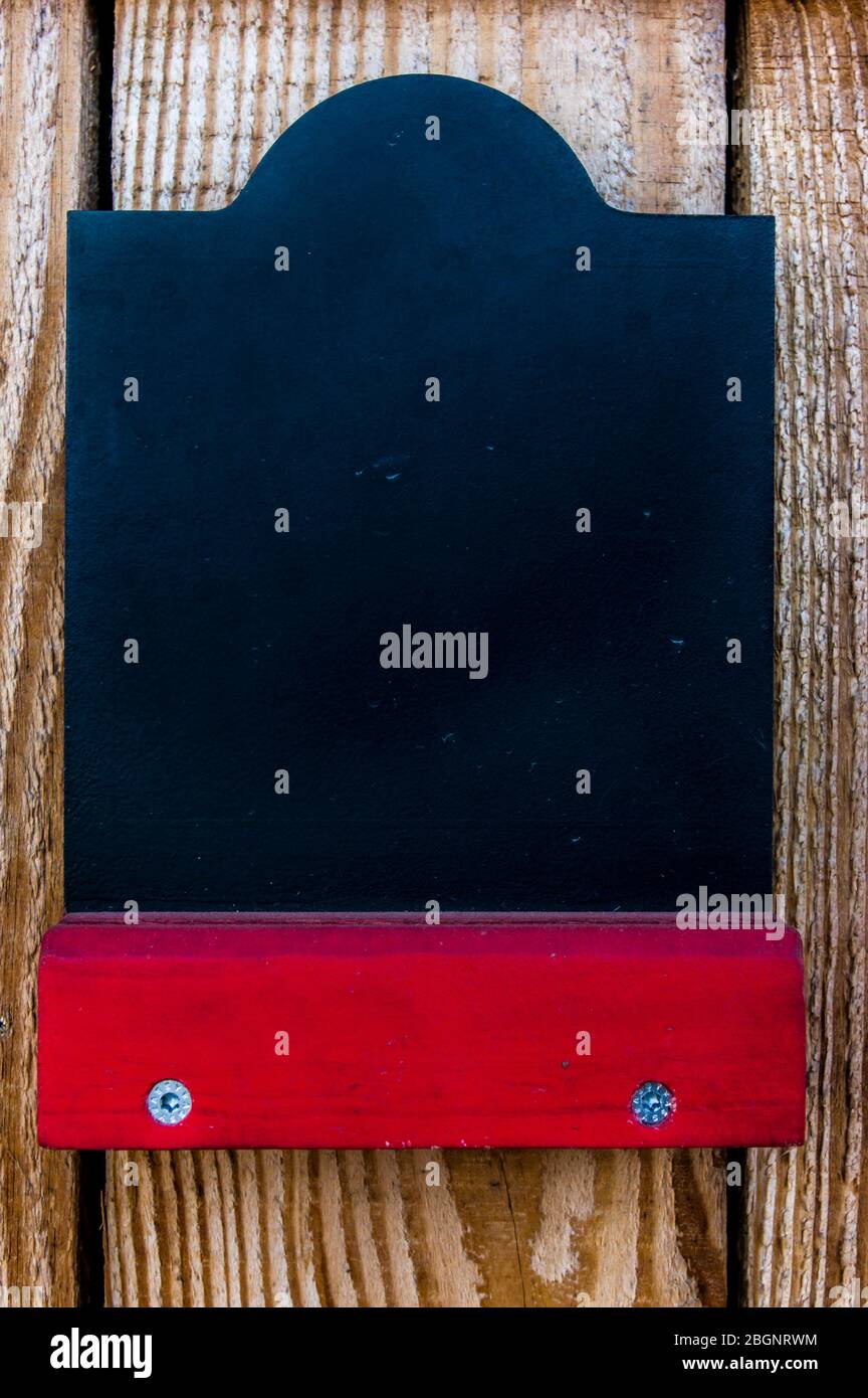 Leere Kreidetafel auf einem Holzstand mit rotem Regal für kostenlose Etikettierung Stockfoto