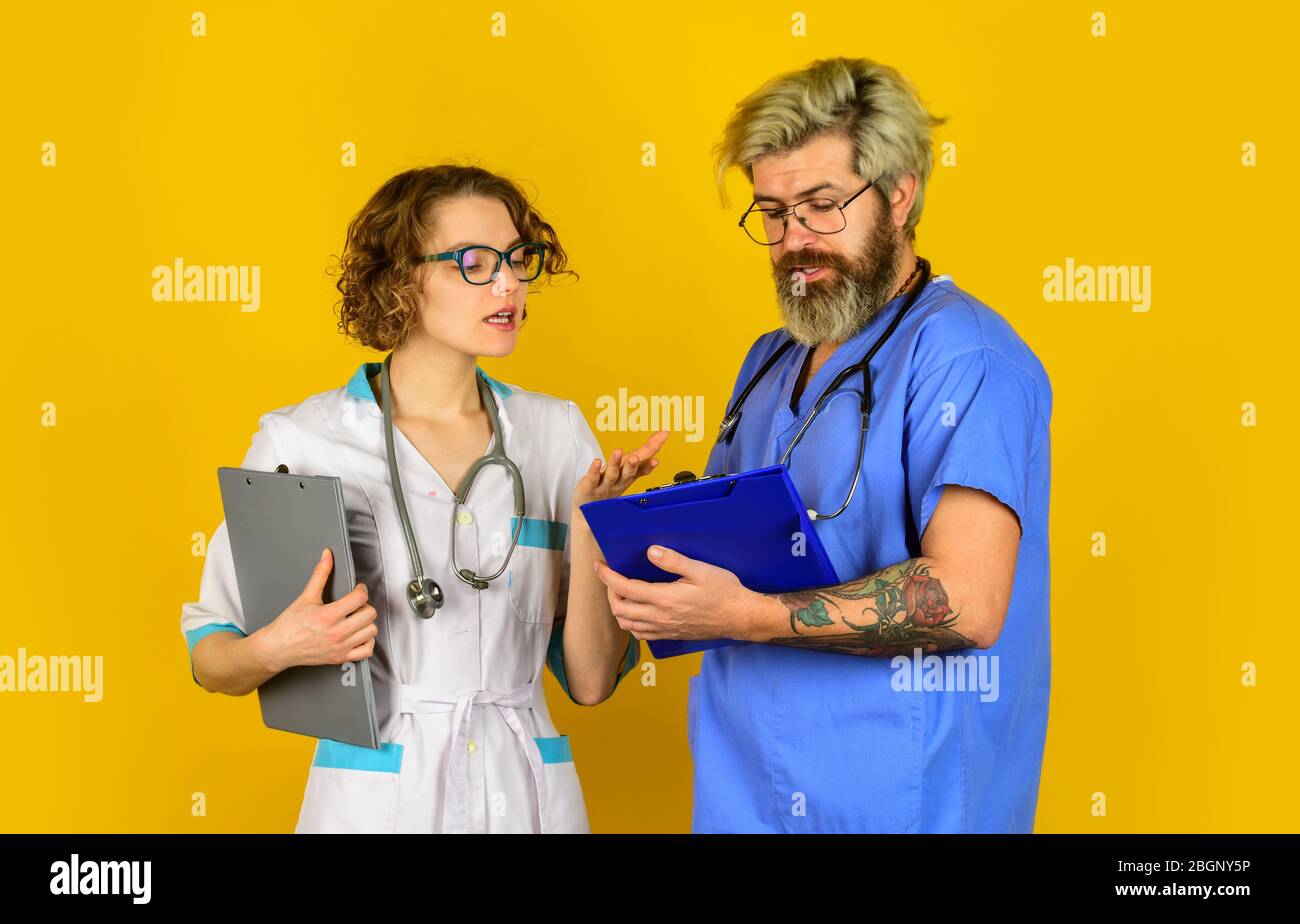 Check in mit Ihrer Gesundheit. Vertrauen Sie unseren Fachleuten. Healthcare Business. Teamwork und Menschen Konzept. Arzt und Krankenschwester. Erfolgreiches Team von Ärzten. Menschen in Uniformen gelben Hintergrund. Stockfoto