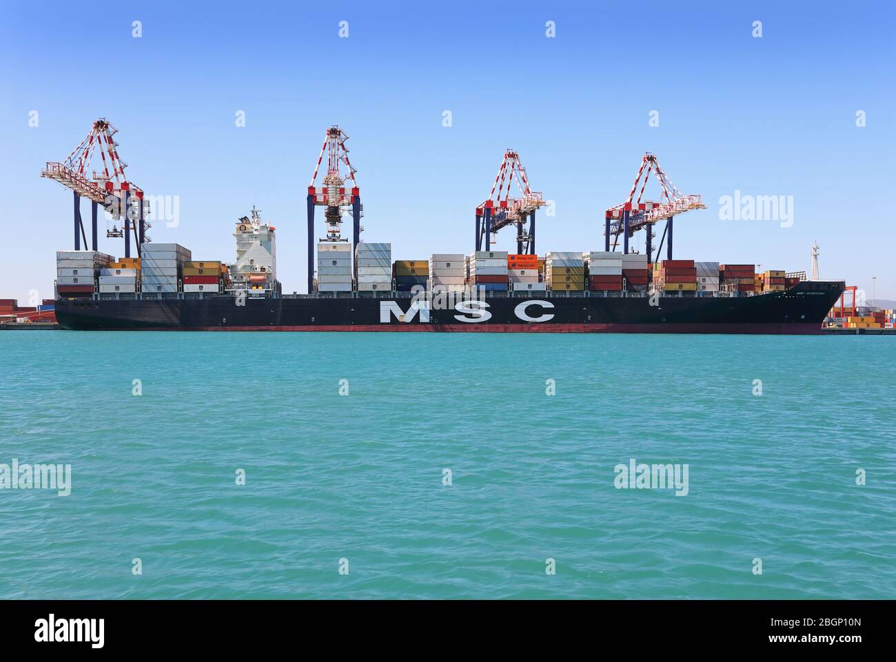 Containerschiff wird durch einen Schlepper positioniert Stockfoto