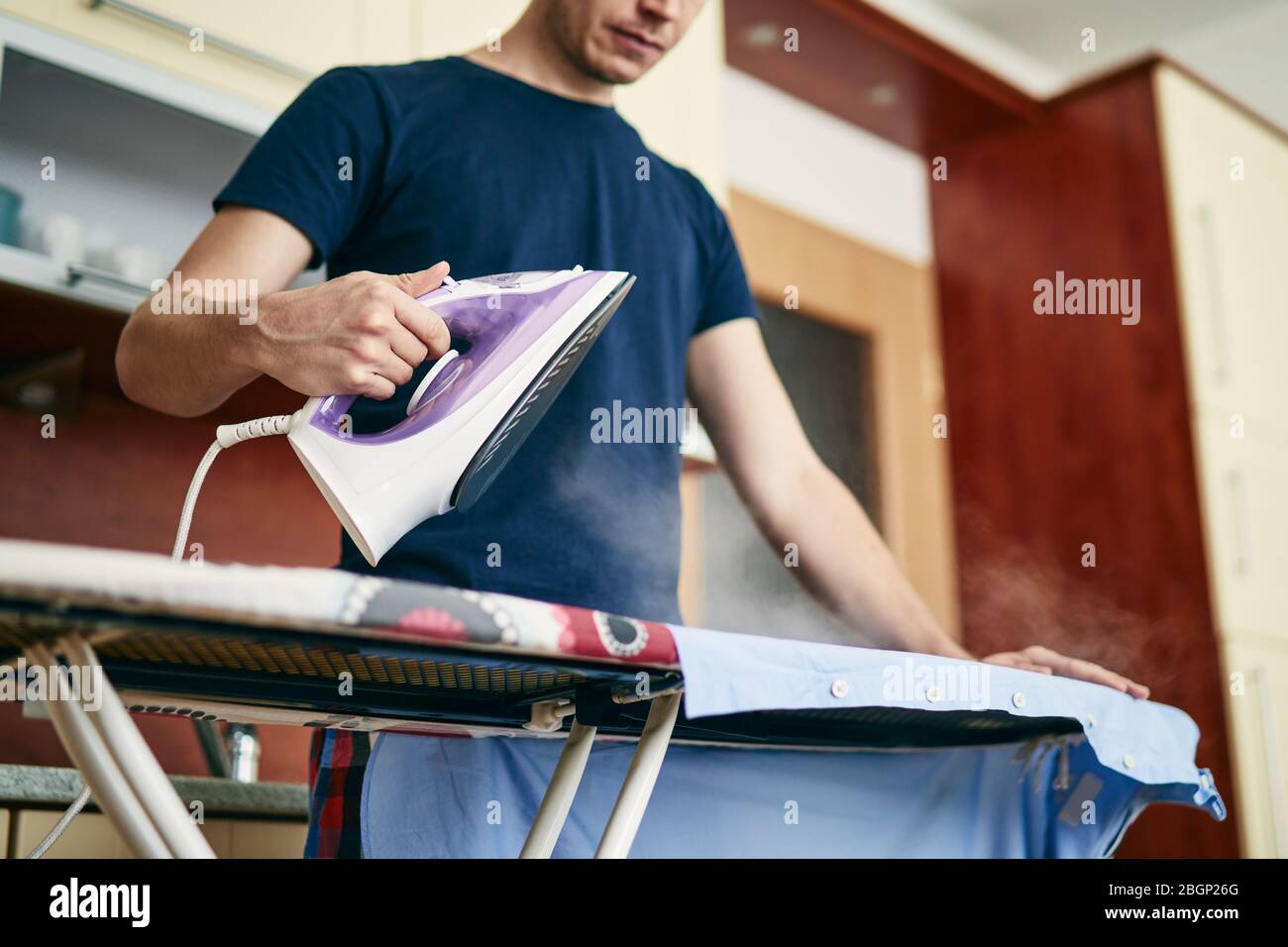 Hausarbeit. Single-Mann-Bügelhemd zu Hause. Stockfoto