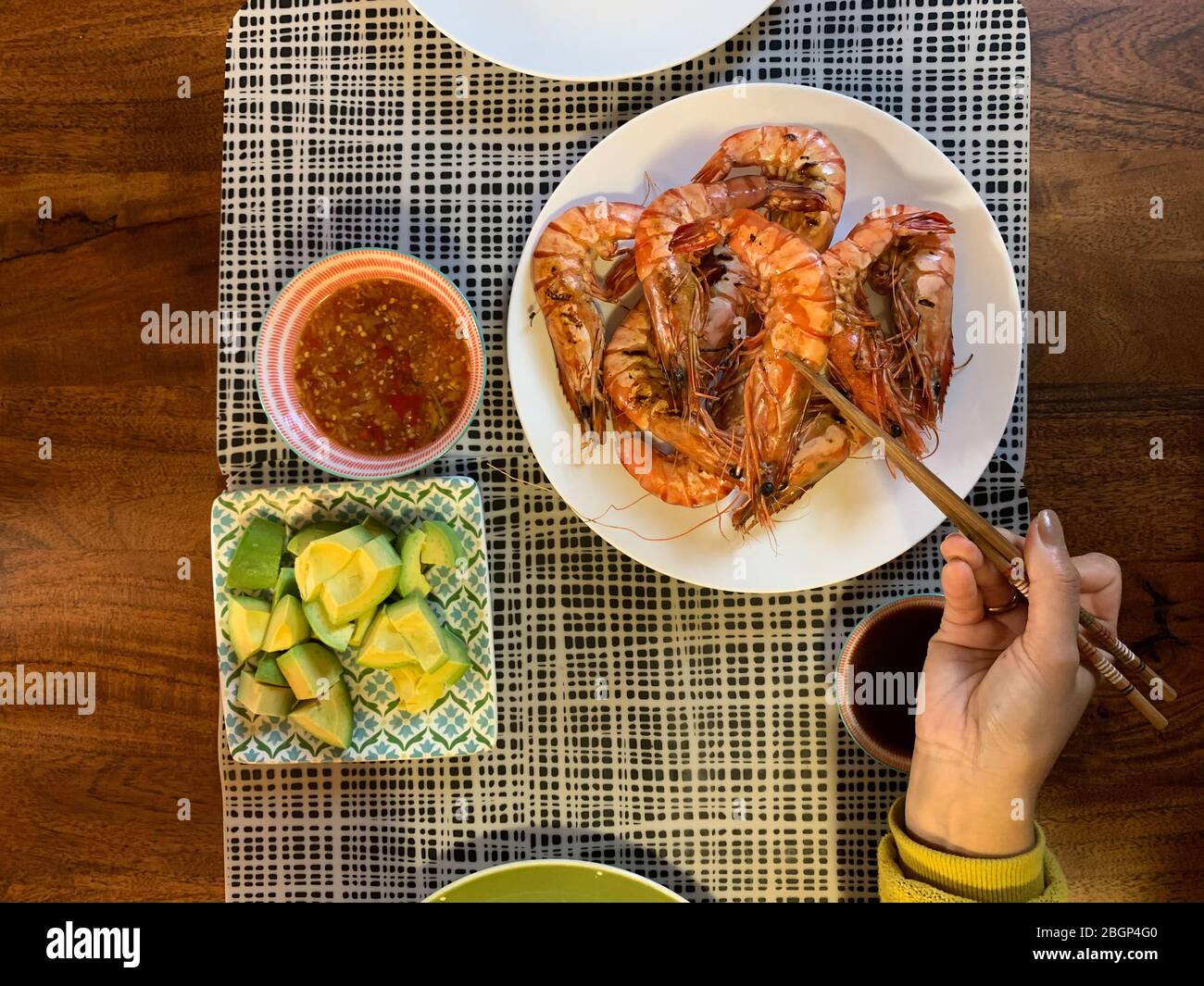 Garnelen oder Tiger Garnelen in weißem Teller auf Esstisch mit Avocado gegrillt. (Selektiver Fokus) Stockfoto