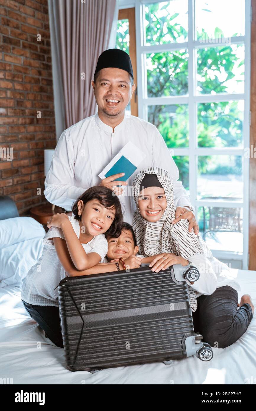 Vater im Besitz des Reisepasses, wenn Familienmitglieder Koffer für getragen vorbereiten, wenn mudik zurück Dorf nach Hause gehen Stockfoto