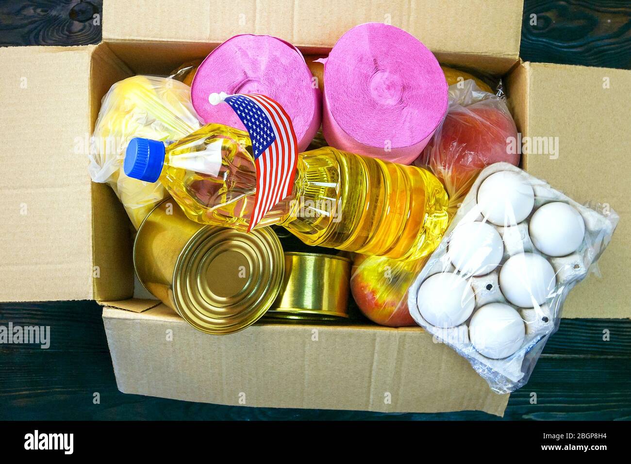 Verschiedene Lebensmittel in Spendenbox für Arme verpackt. Konserven, Öl, Eier, Obst, Nudeln. Draufsicht, flaches Lay. Nahaufnahme. Drinnen. Stockfoto