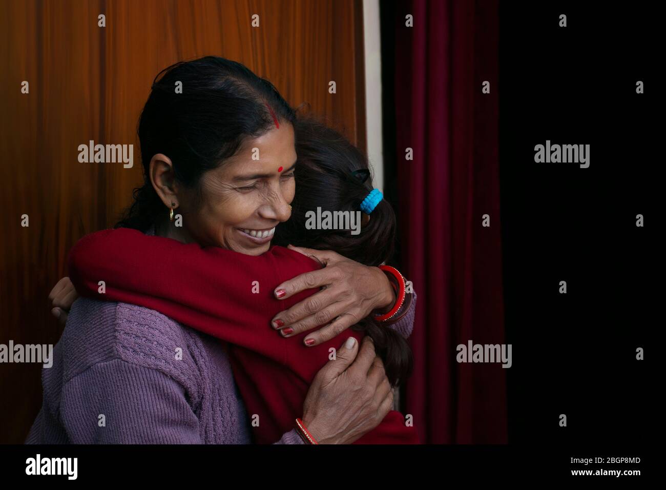 Glückliche ältere Frau umarmt ihre Tochter oder Enkelin Stockfoto