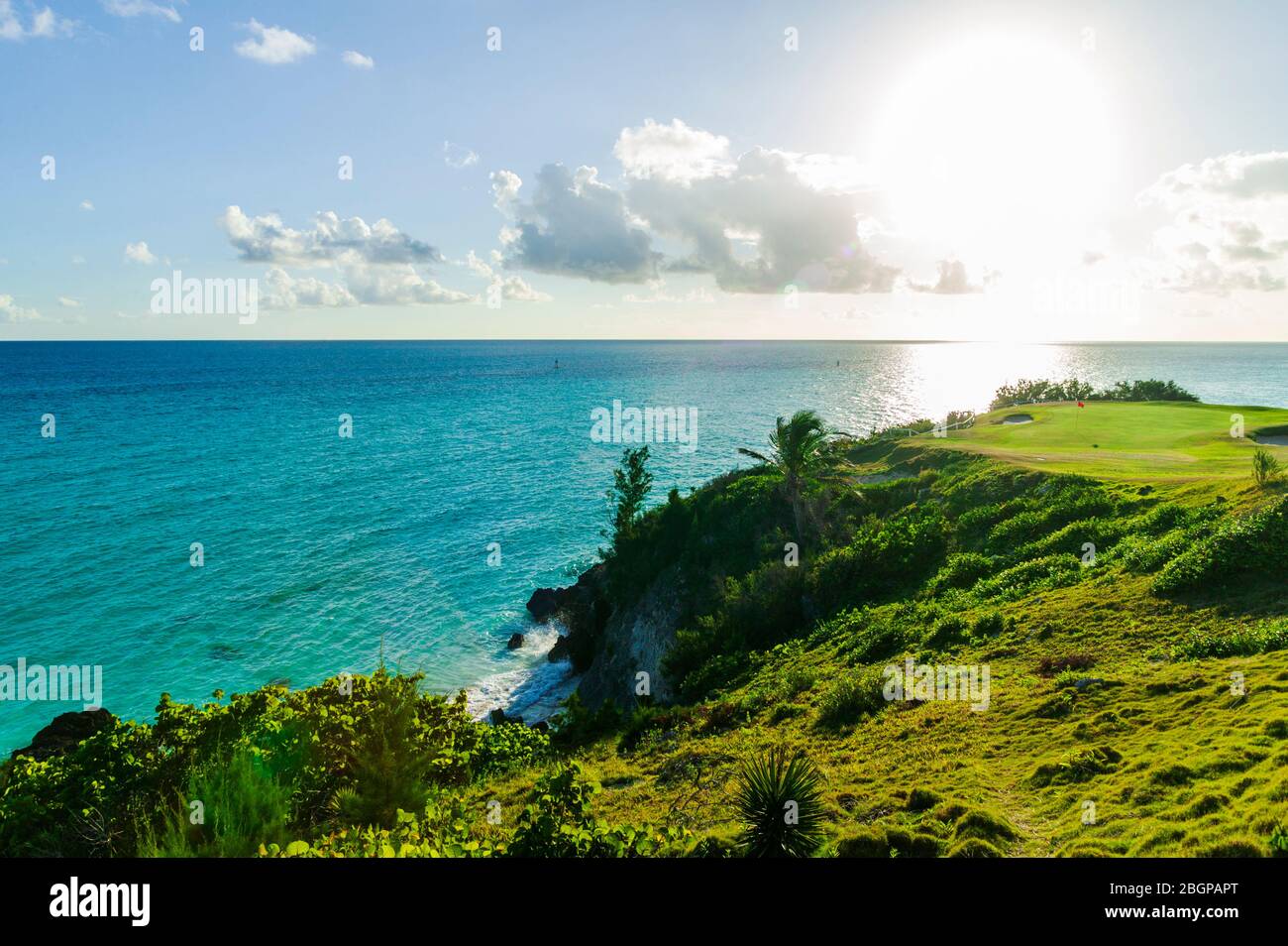 Männliche Touristen im Urlaub schlagen einen Golfball aus einer Sandfalle in der Nähe eines grünen, Port Royal Golfplatz Stockfoto