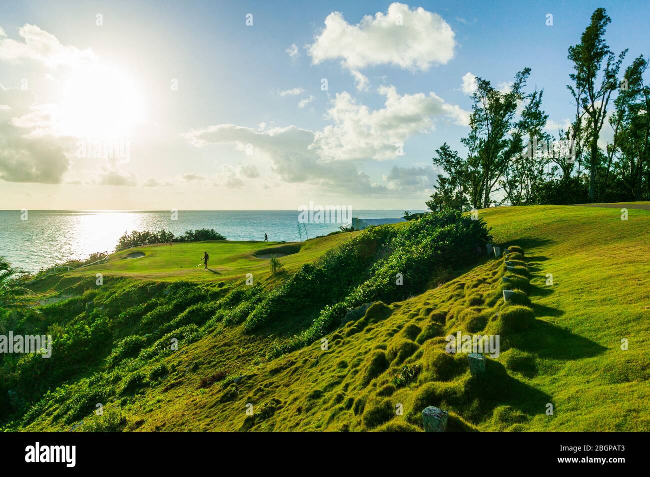 Männliche Touristen im Urlaub schlagen einen Golfball aus einer Sandfalle in der Nähe eines grünen, Port Royal Golfplatz Stockfoto