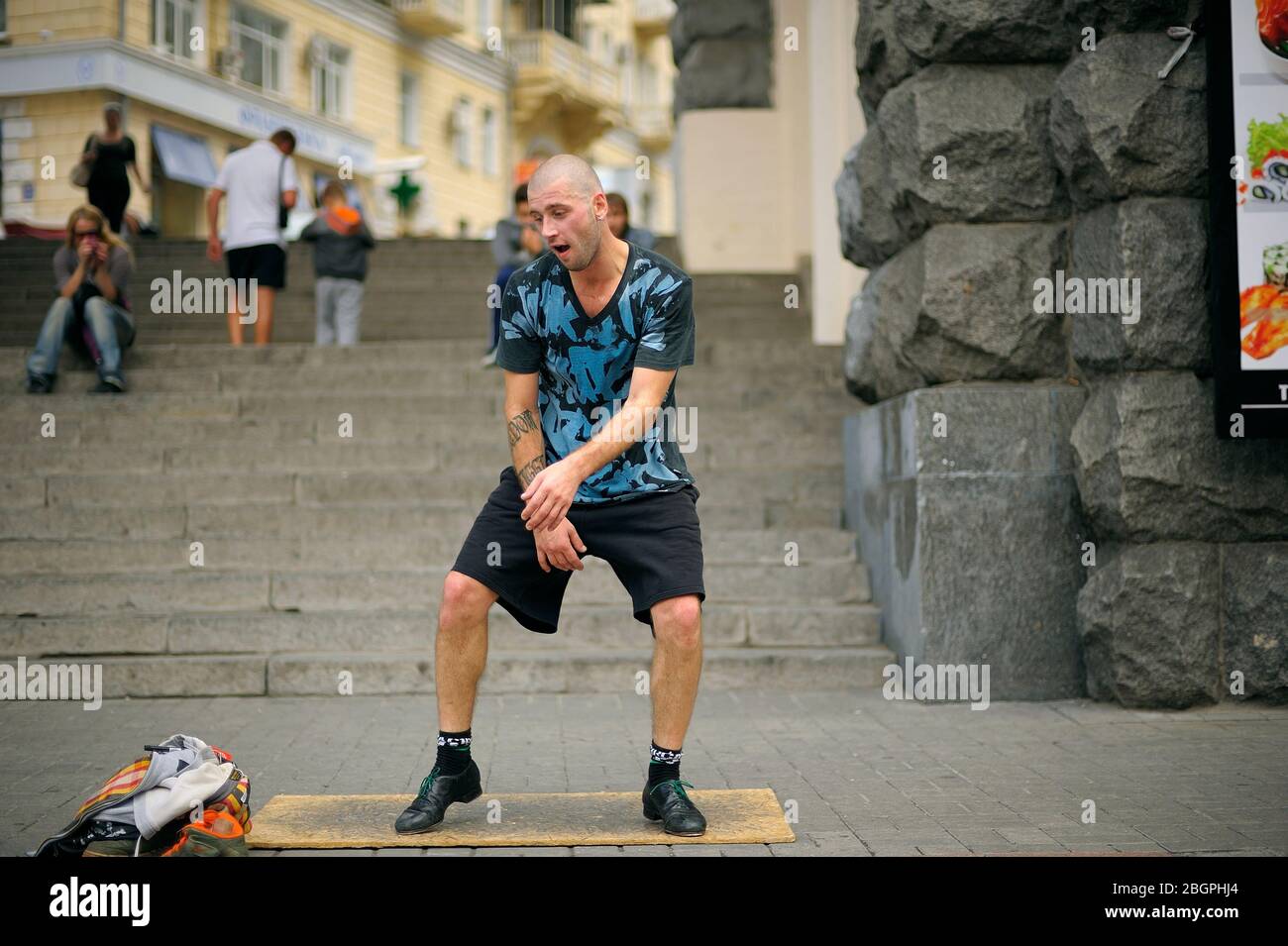 Junger Mann, Straßentänzer, der auf dem Bürgersteig einen Stepptanz vorführt Stockfoto