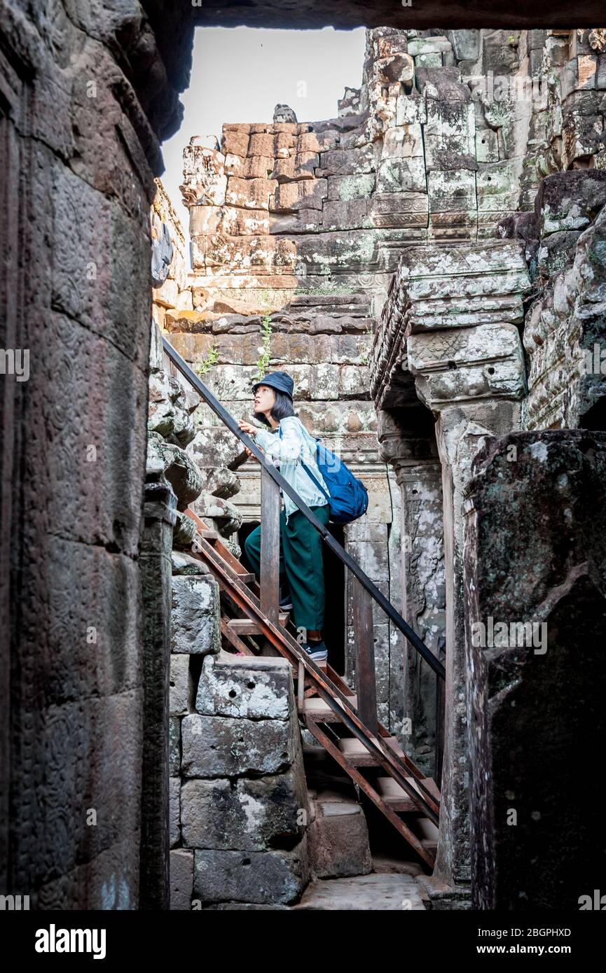 Asiatische Touristen machen ihren Weg durch die alten Tempel von Angkor Wat, Kambodscha. Selfies machen, Leitern klettern, durch die Gänge gehen und nehmen Stockfoto