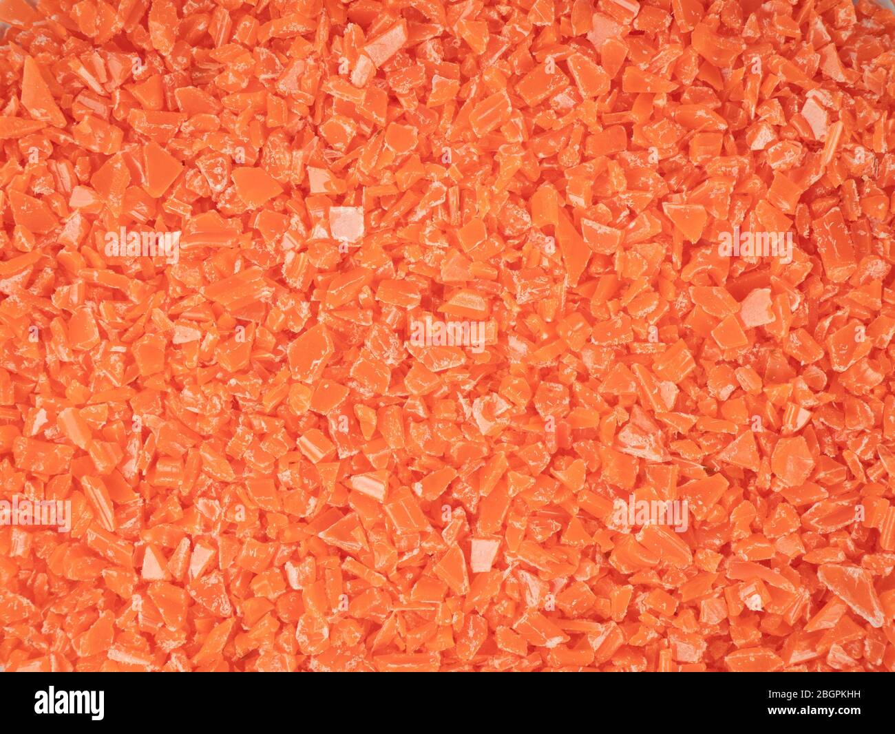 Orangefarbene Schrott-Stücke aus Kunststoff Produktion Hintergrund Stockfoto