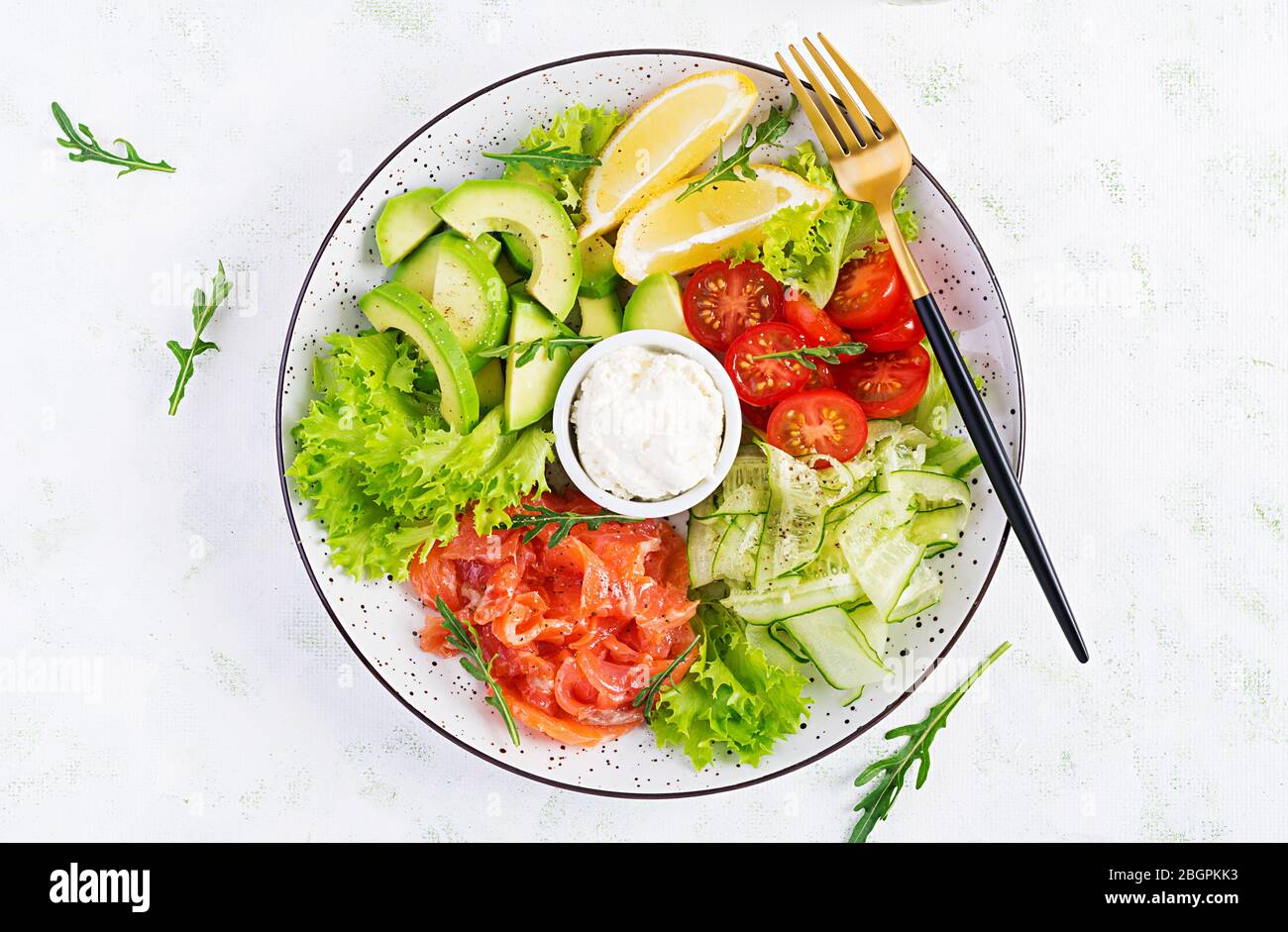 Salat aus gesalzenem Fisch, Lachs, Avocado, Kirschtomaten, Gurke, Salat und Frischkäse. Fischmenü. Diätmenü. Meeresfrüchte - Lachs. Draufsicht Stockfoto
