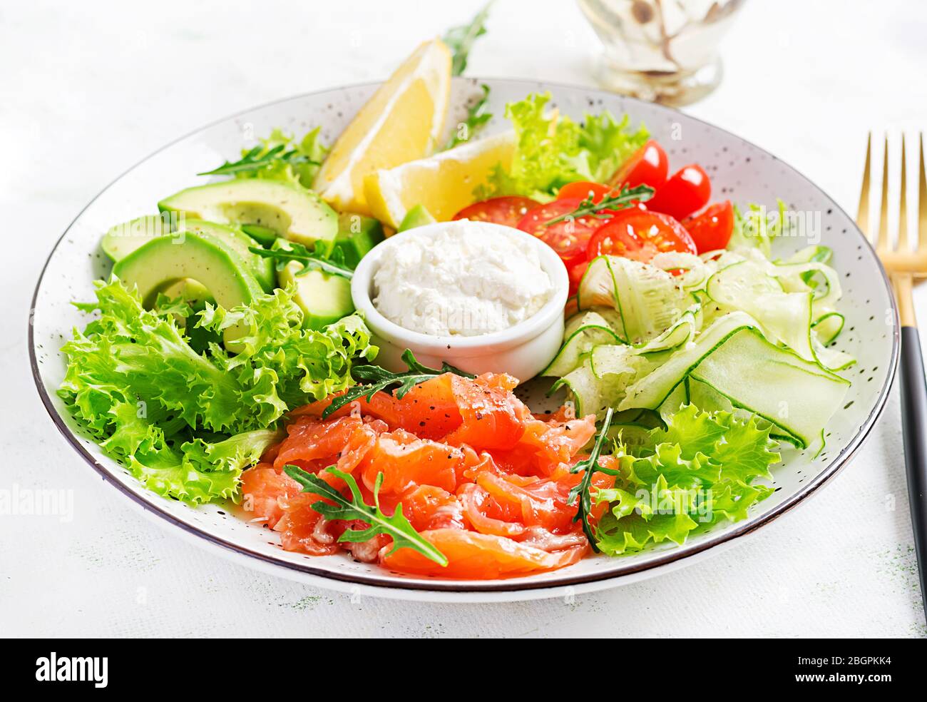 Salat aus gesalzenem Fisch, Lachs, Avocado, Kirschtomaten, Gurke, Salat und Frischkäse. Fischmenü. Diätmenü. Meeresfrüchte - Lachs. Stockfoto
