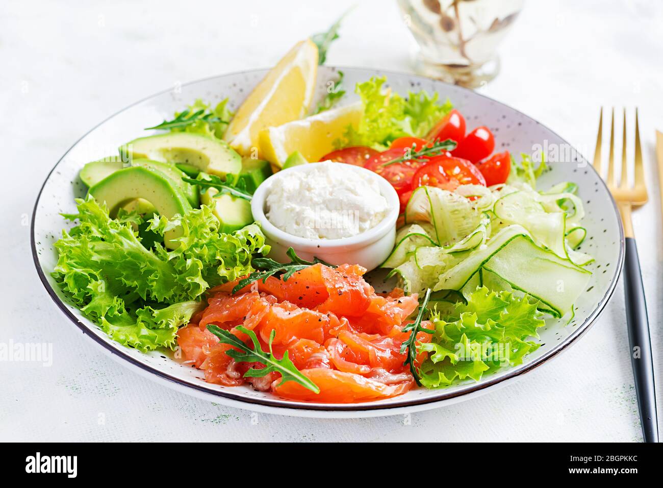 Salat aus gesalzenem Fisch, Lachs, Avocado, Kirschtomaten, Gurke, Salat und Frischkäse. Fischmenü. Diätmenü. Meeresfrüchte - Lachs. Stockfoto