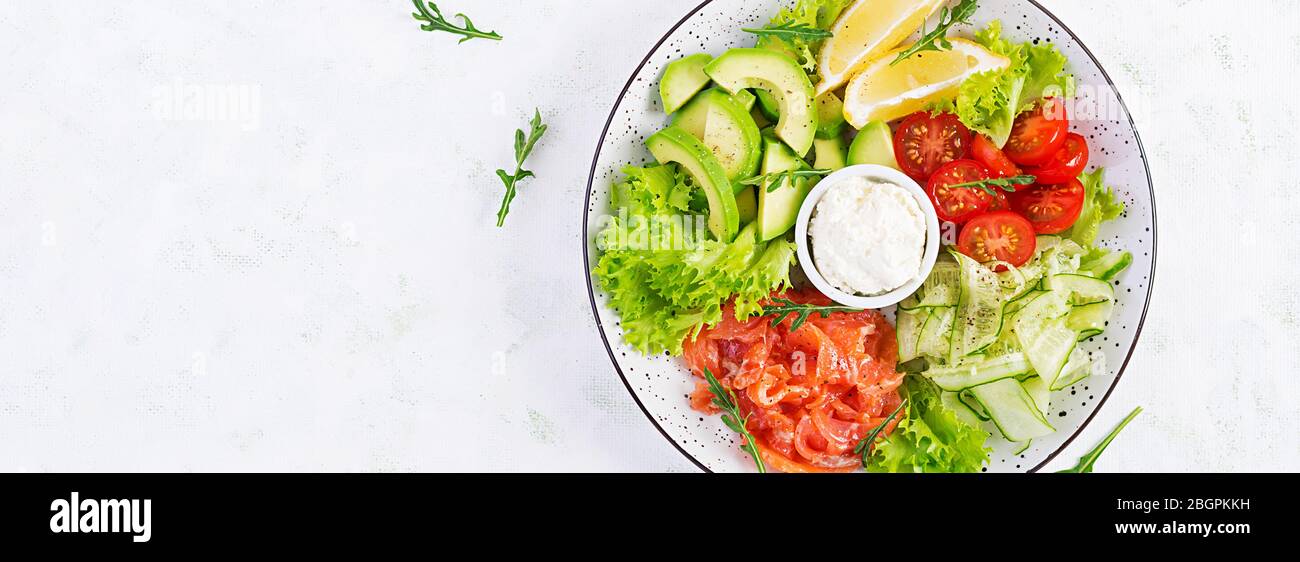 Salat aus gesalzenem Fisch, Lachs, Avocado, Kirschtomaten, Gurke, Salat und Frischkäse. Fischmenü. Diätmenü. Meeresfrüchte - Lachs. Draufsicht Stockfoto