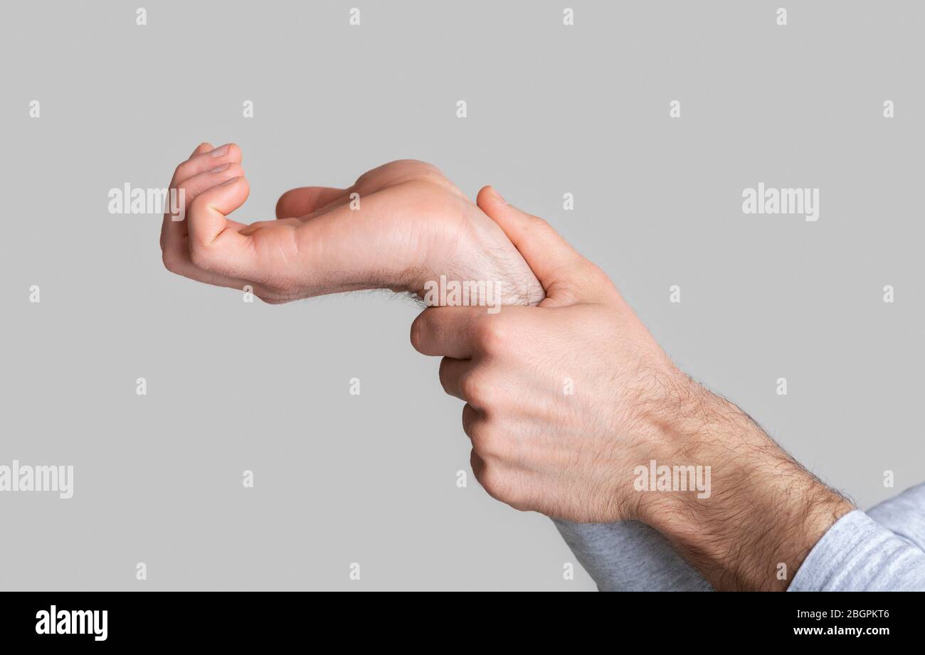 Schmerzen am Handgelenk. Mann massiert Gelenk in der Hand Stockfoto
