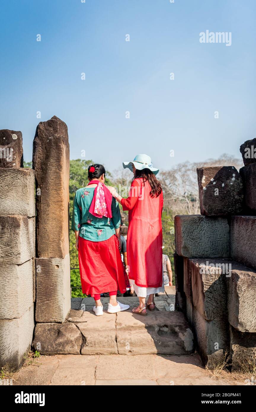 Asiatische Touristen machen ihren Weg durch die alten Tempel von Angkor Wat, Kambodscha. Selfies machen, Leitern klettern, durch die Gänge gehen und nehmen Stockfoto