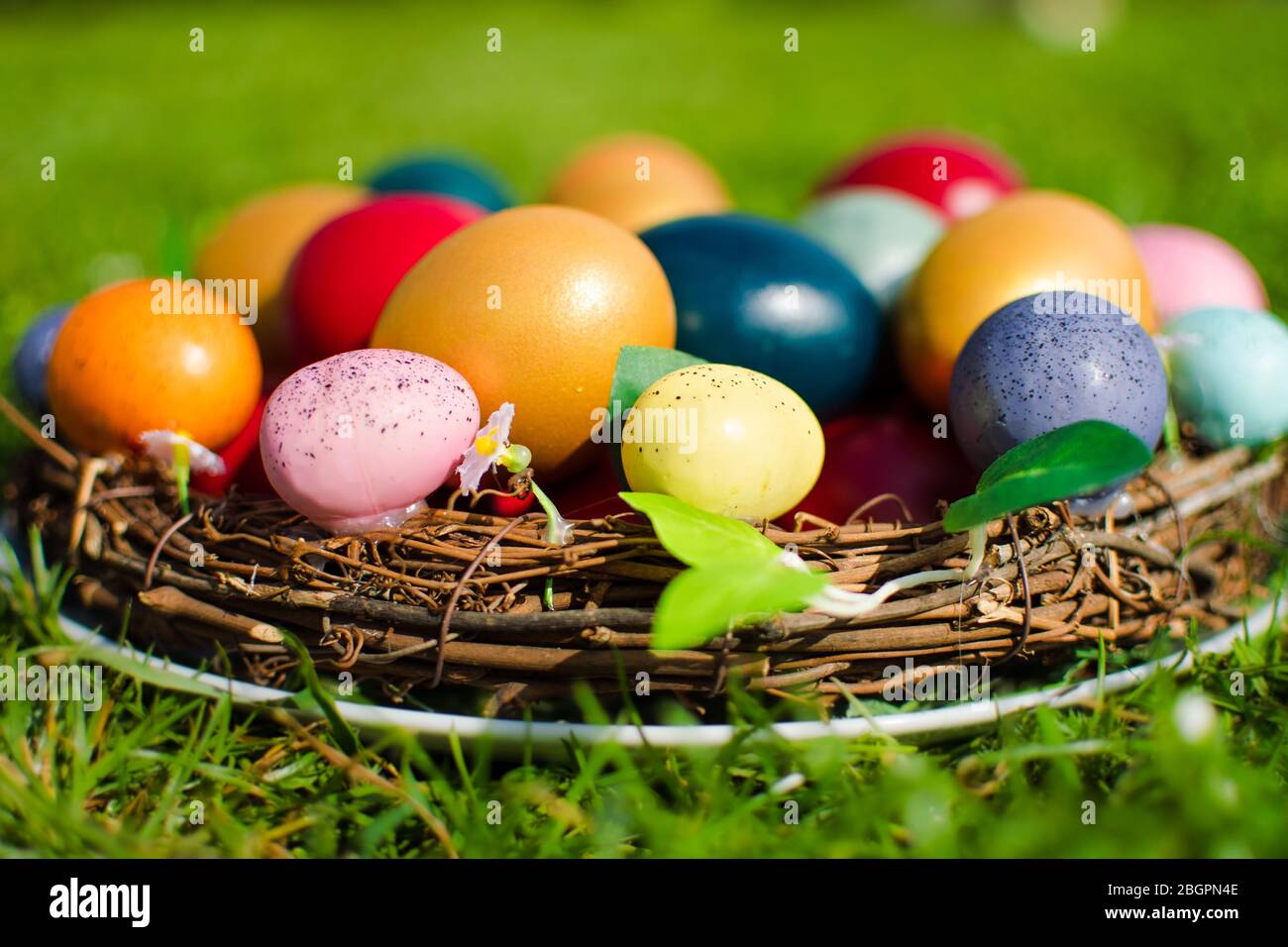 Stockfoto von Ostereiern in einem Holzkorb auf grünem Gras als Symbol des Osterfestes in der christlichen Religion. Stockfoto