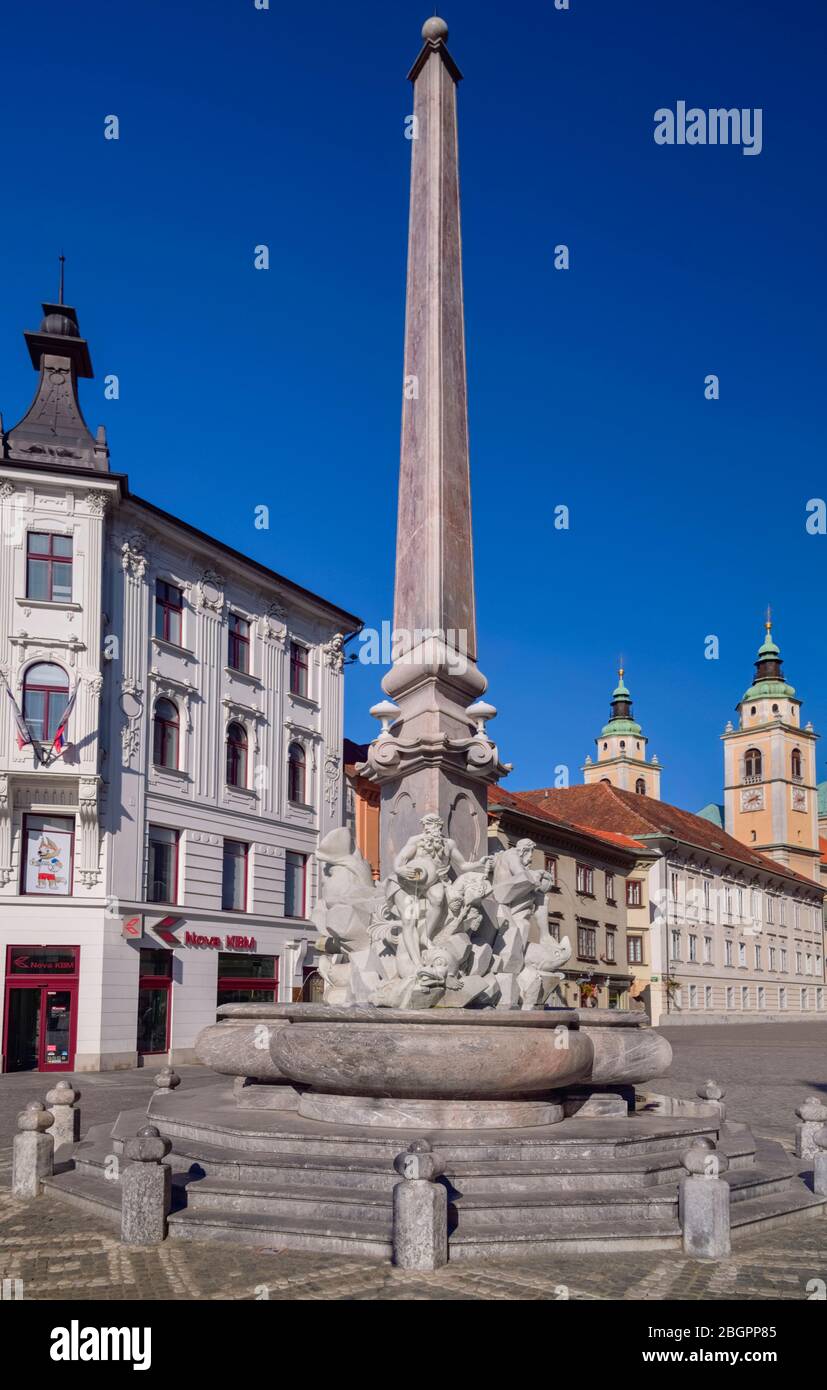 Slowenien, Ljubljana, vollständige Ansicht des Robba-Brunnens mit Türmen und Kuppel der Kathedrale des Heiligen Nikolaus im Hintergrund. Stockfoto