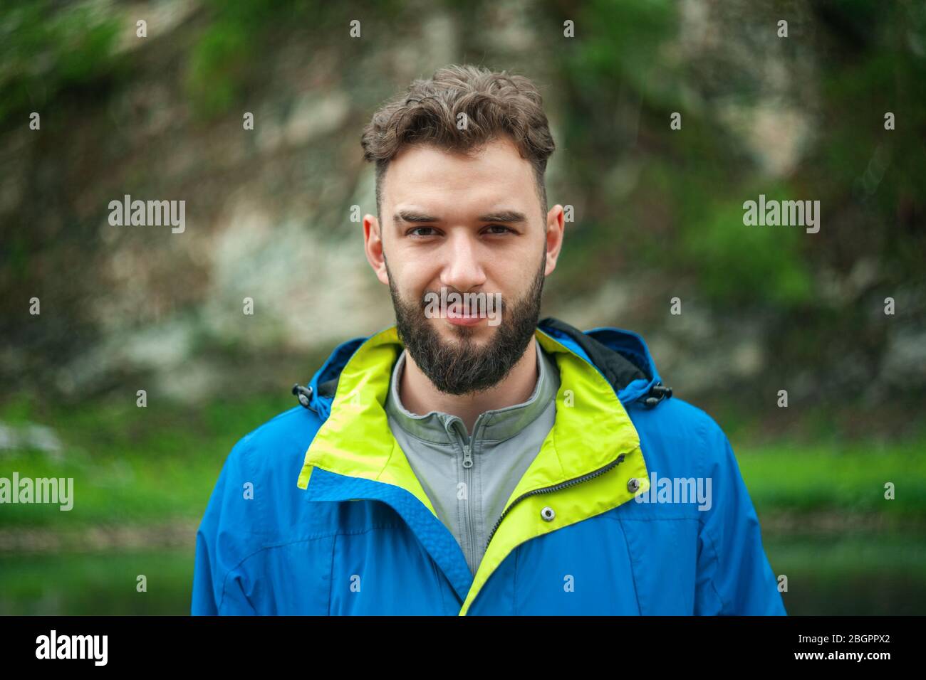 Porträt eines jungen, bärtigen Mannes, auf, vor einem Hintergrund der Tierwelt. Das Konzept von Expedition, Abenteuer und Camping-Leben. Stockfoto