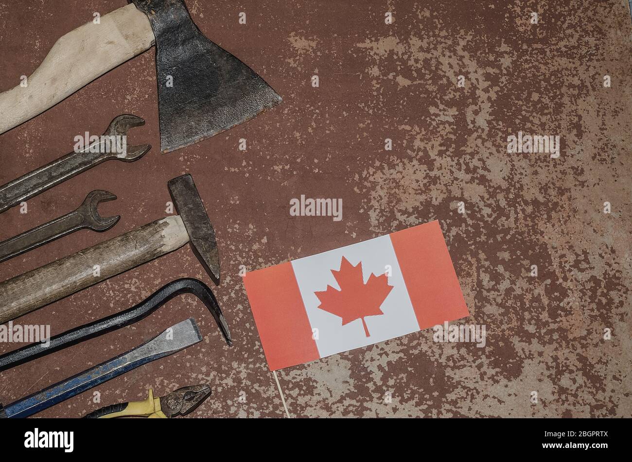 Labor Day in Kanada, 1. Mai. Viele praktische Werkzeuge auf altem rostigen Hintergrund mit Kanada Flagge mit Kopierraum. Reparatur, Werkstatt. Stockfoto