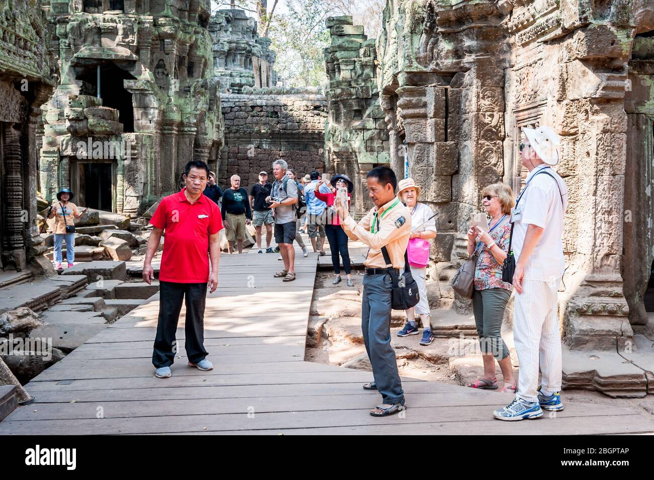 Touristen und Führer machen sich auf den Wegen des Angkor Wat Tempels, Siem Reap Provinz, Kambodscha. Stockfoto