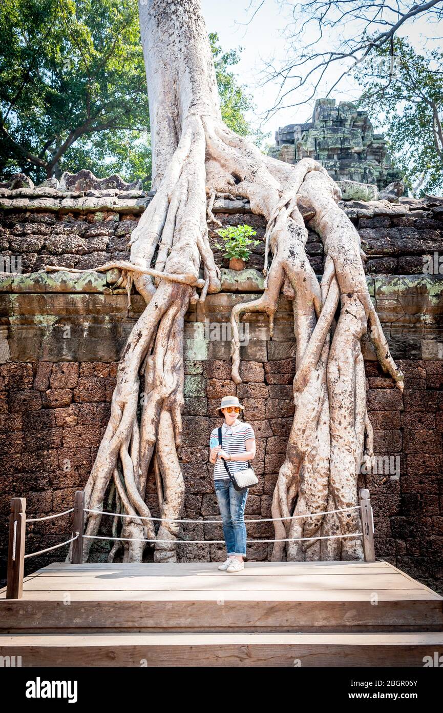 Ein junger asiatischer Tourist posiert für ein Foto zwischen den Ruinen von Angkor Wat, Provinz Siem Reap, Kambodscha. Stockfoto