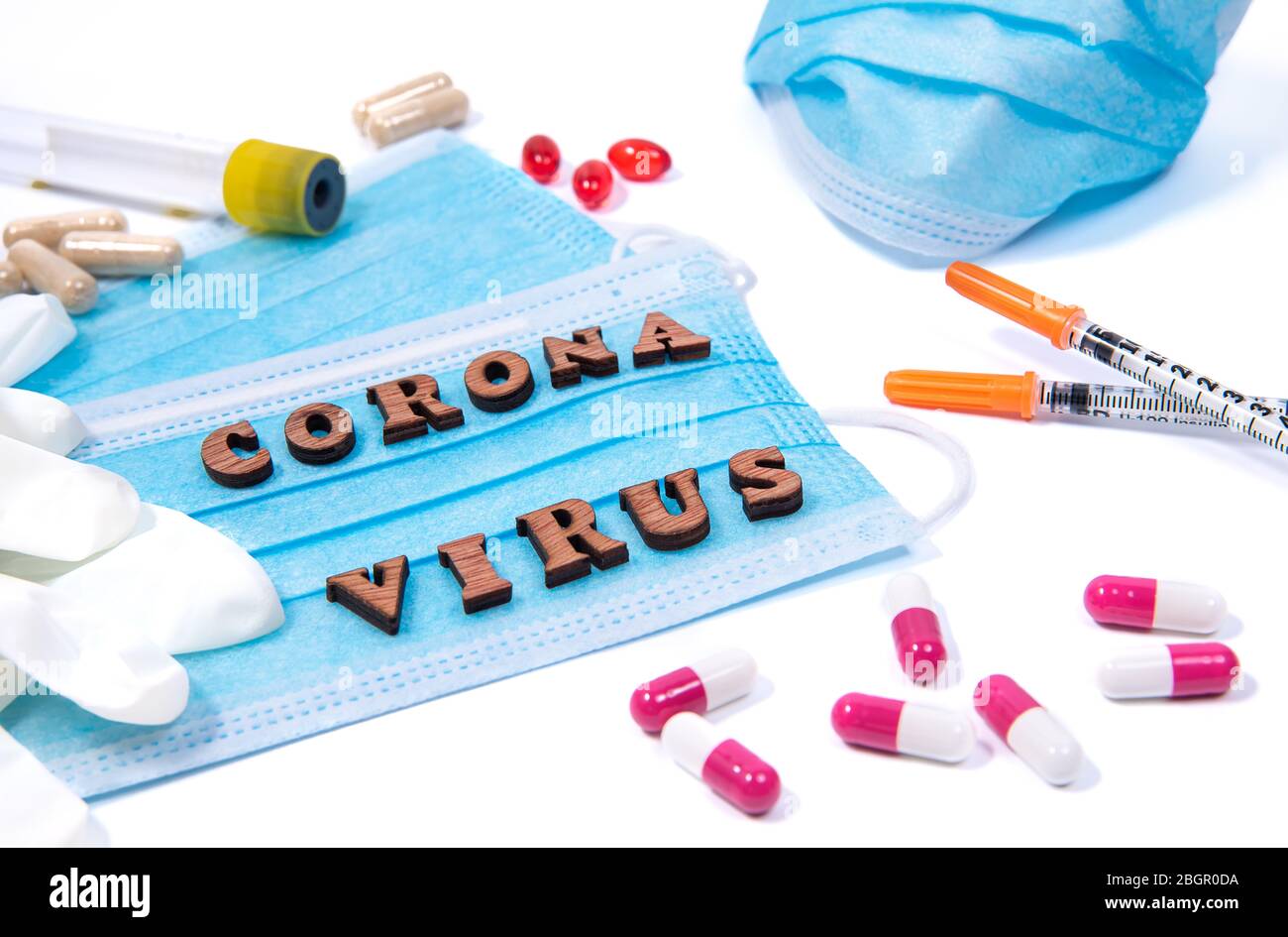 Medizinische Ausrüstung, Maske und Pillen um Buchstaben von Wörtern Corona Virus auf weißem Hintergrund. Warnkonzept für Virenschutz-Pandemie Stockfoto