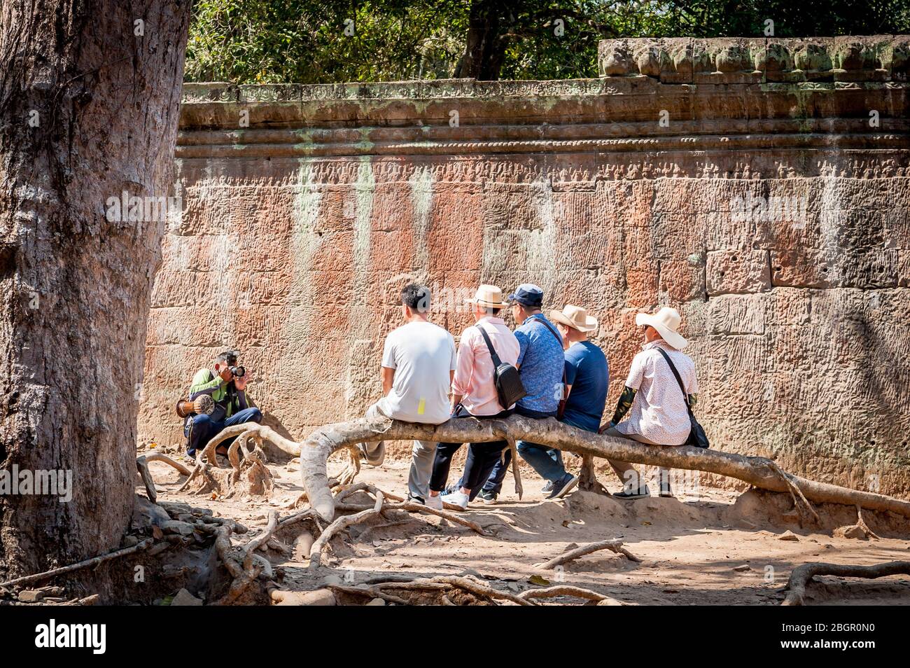 Eine Gruppe asiatischer Touristen posiert für ihr Foto zwischen den Ruinen von Angkor Wat, Provinz Siem Reap, Kambodscha. Stockfoto